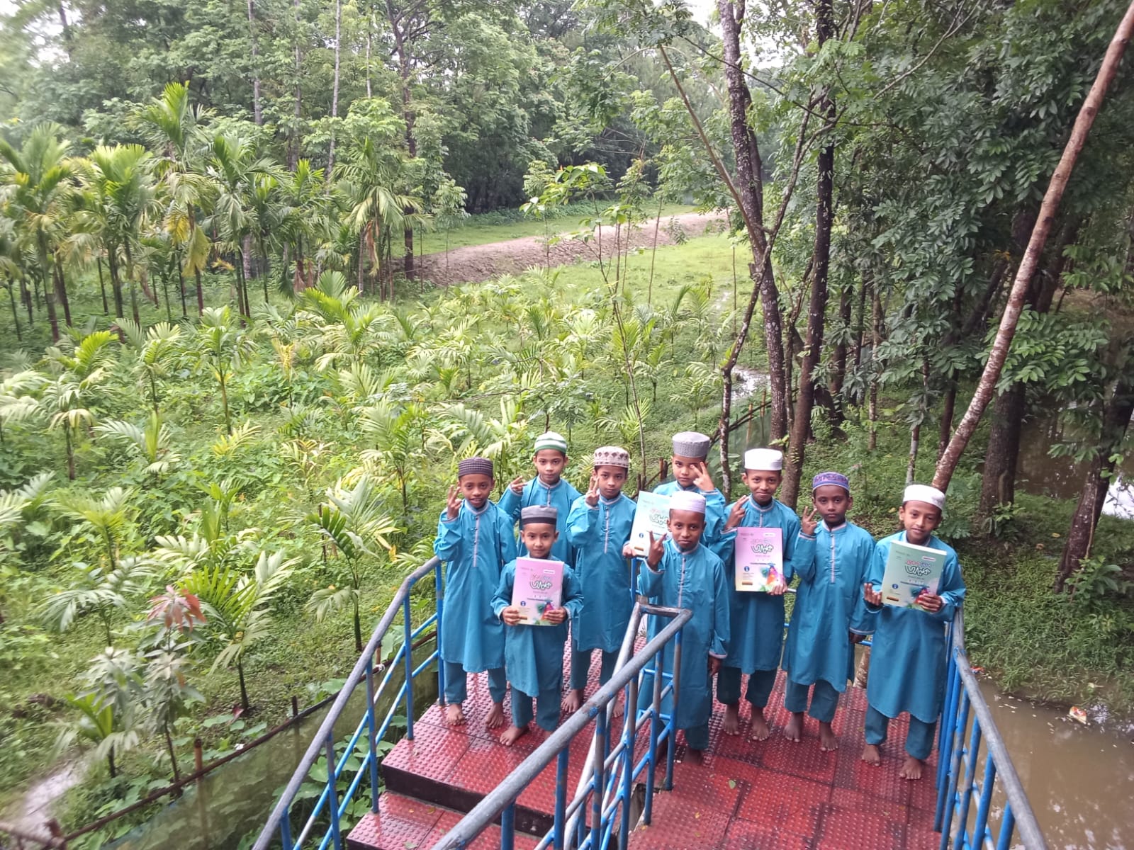 Students proudly holding their books on the bridge
